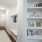 ntry hallway of an apartment featuring warm wood floors, a cozy mudroom area with storage, and built-in bookshelves along the wall.