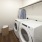 Walk-in laundry room featuring full-size washer and dryer, built-in shelves for organization, and a hanging rack for drying clothes.