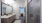 Primary bathroom featuring a sleek stand-up shower, large sink with ample counter space, framed mirror, and bright, stylish lighting.