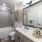 Secondary bathroom featuring a shower and tub combination, spacious sink with countertop, framed mirror, and bright overhead lighting.